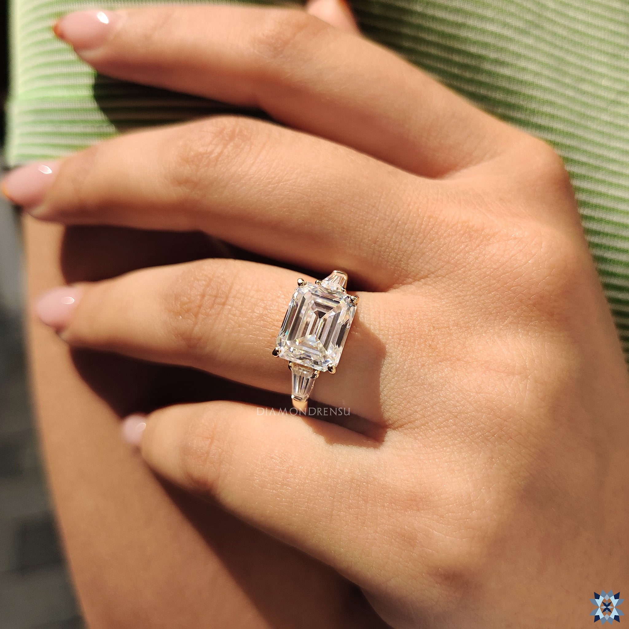 Yellow gold ring featuring three moissanite stones in secure prong mount.
