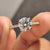 Round cut moissanite engagement ring set in classic cathedral setting.
