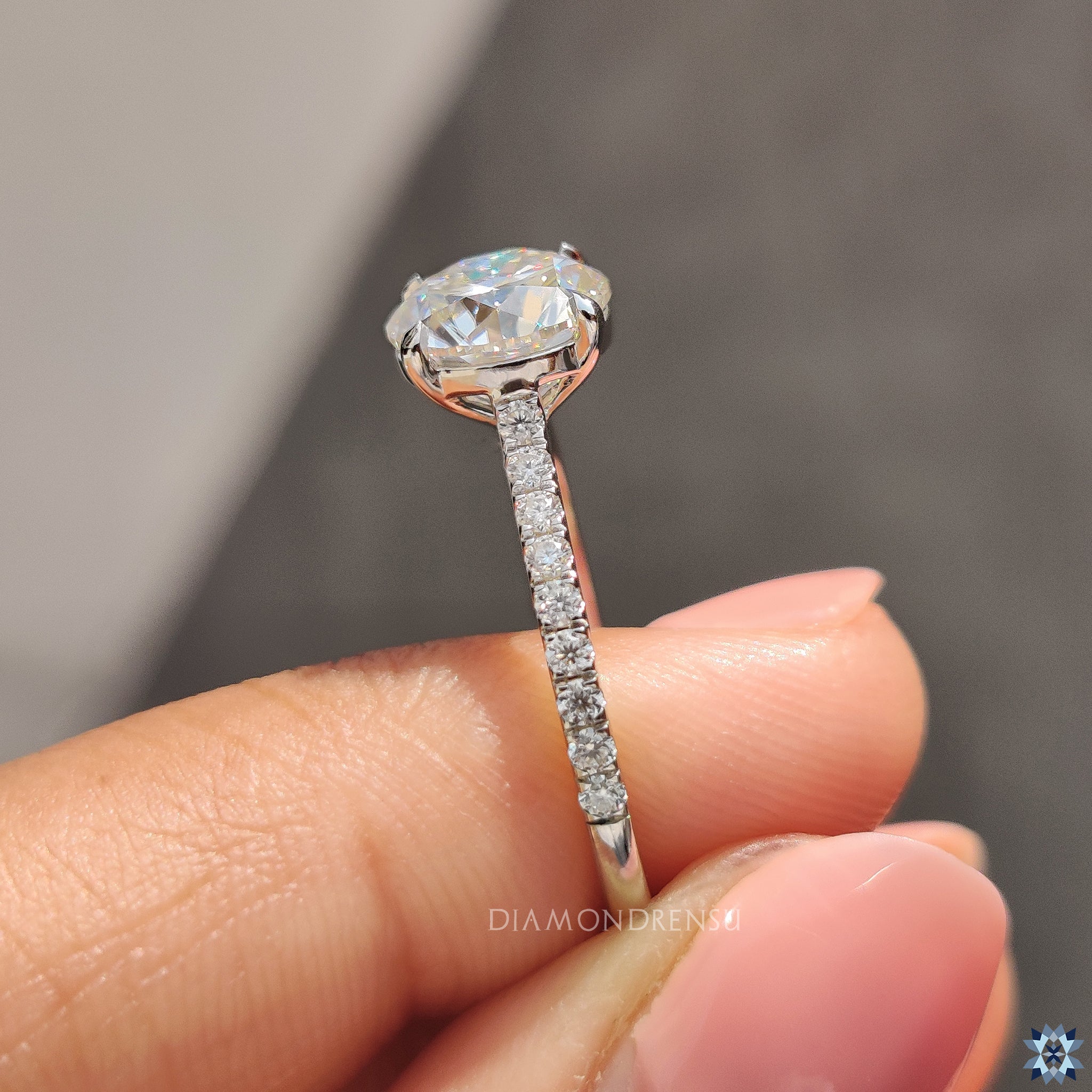 Handmade ring with round moissanite and round cut pave accents.
