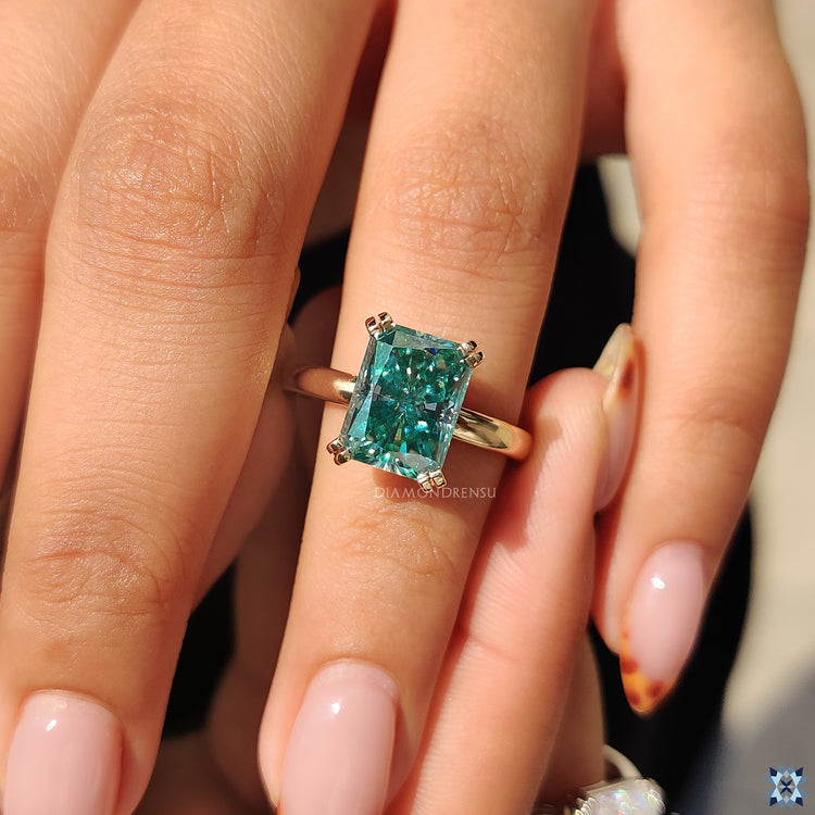 Radiant cut moissanite ring set in classic yellow gold band.
