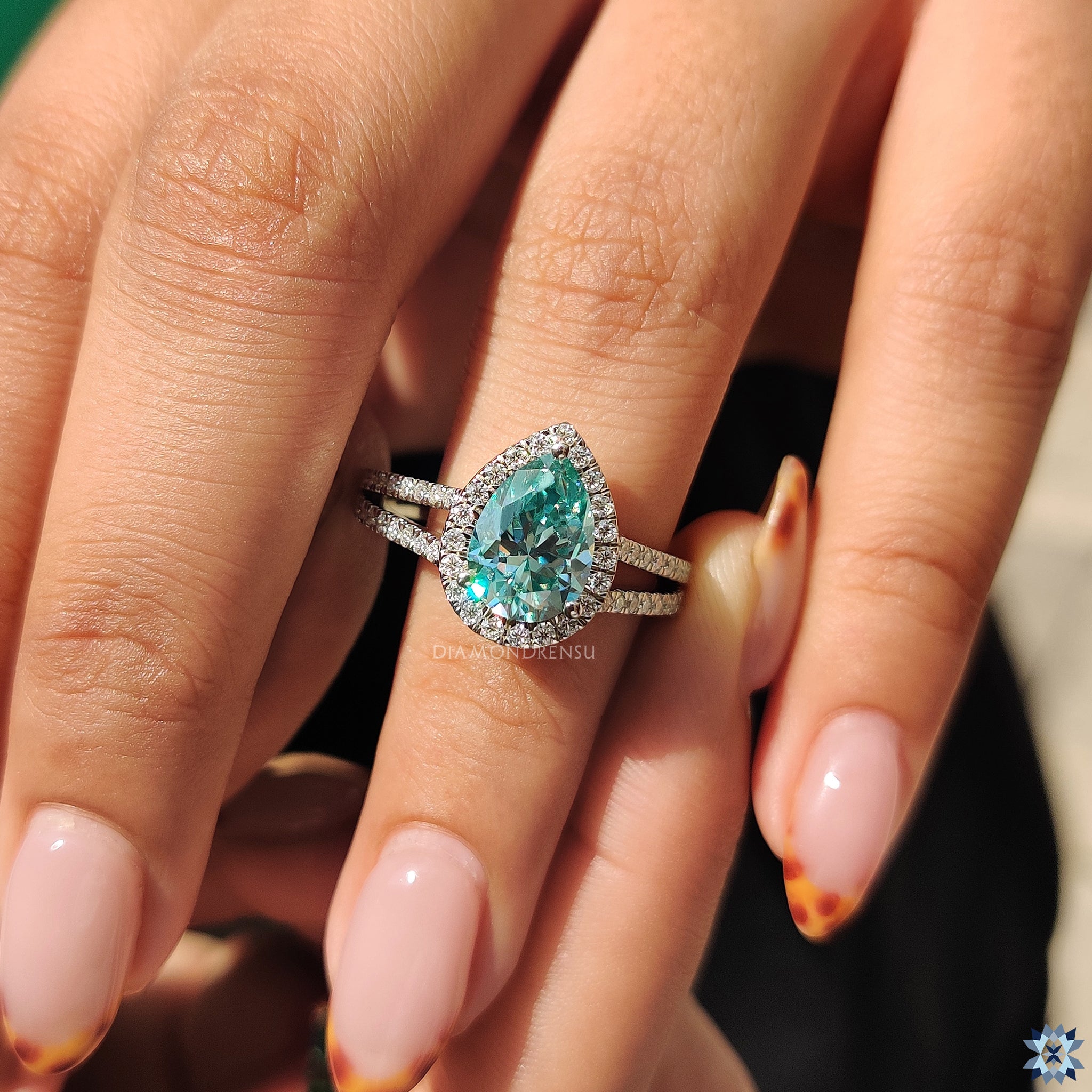 Diamondrensu UK ring with pear cut and round halo detailing.
