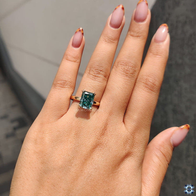 Cyan blue moissanite ring in bold radiant cut and prong mount.
