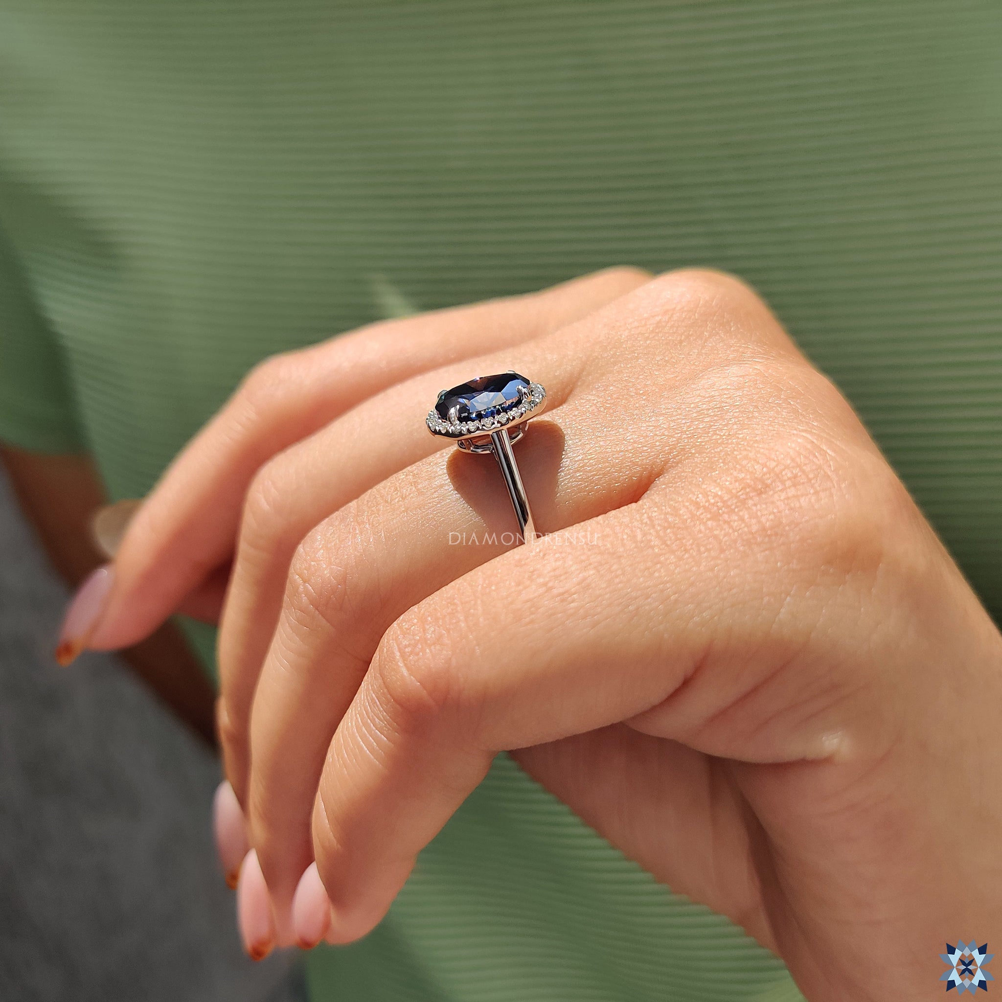Oval blue moissanite ring set in white gold with secure 4 claw prongs and halo sparkle.
