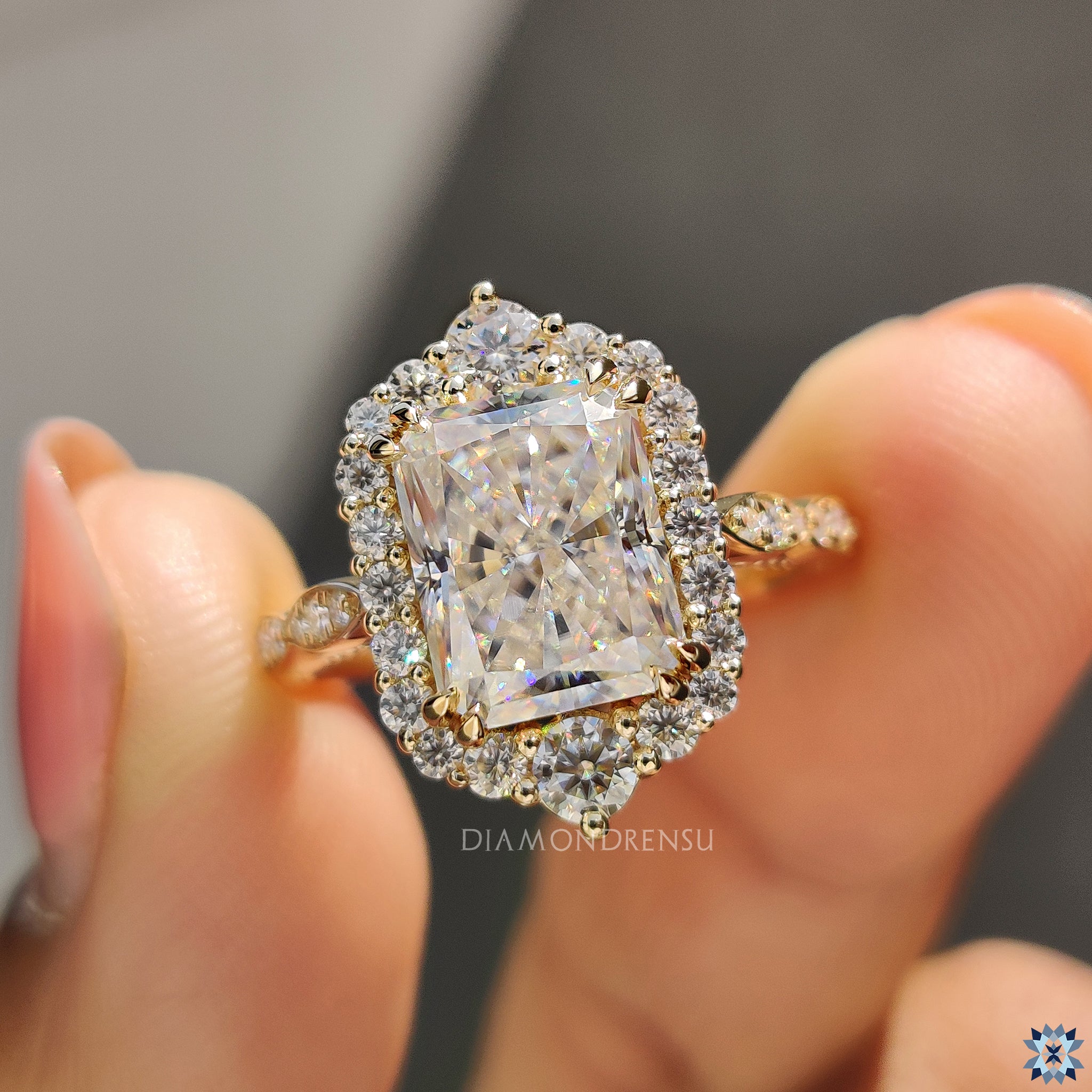 Buy engagement ring with radiant cut centre and classic round cut halo accents.
