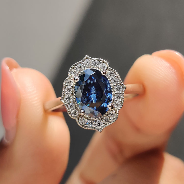 Oval Moissanite engagement ring with royal dark blue center stone and vintage halo design.
