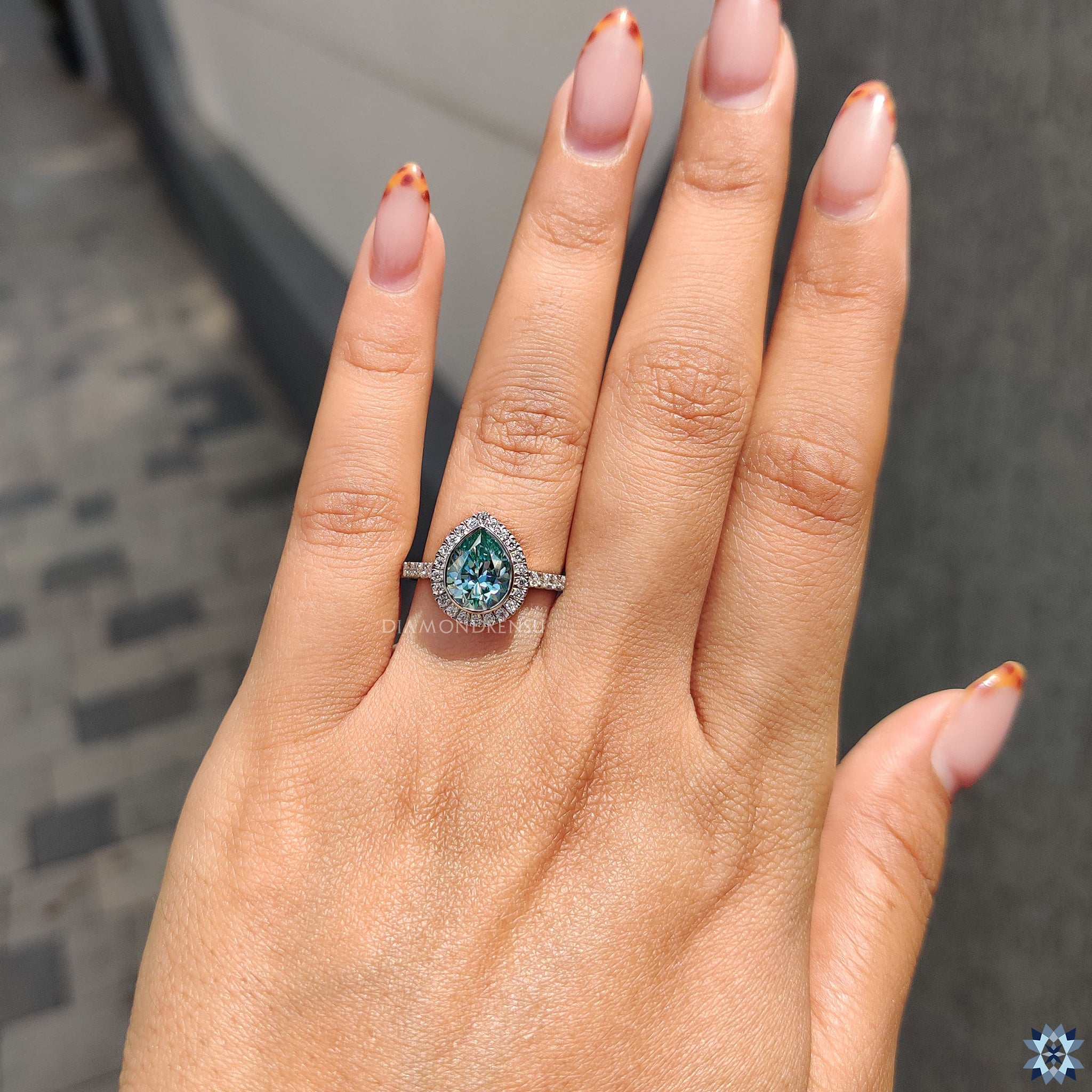 Handmade jewelry ring with cyan blue pear moissanite in halo setting.
