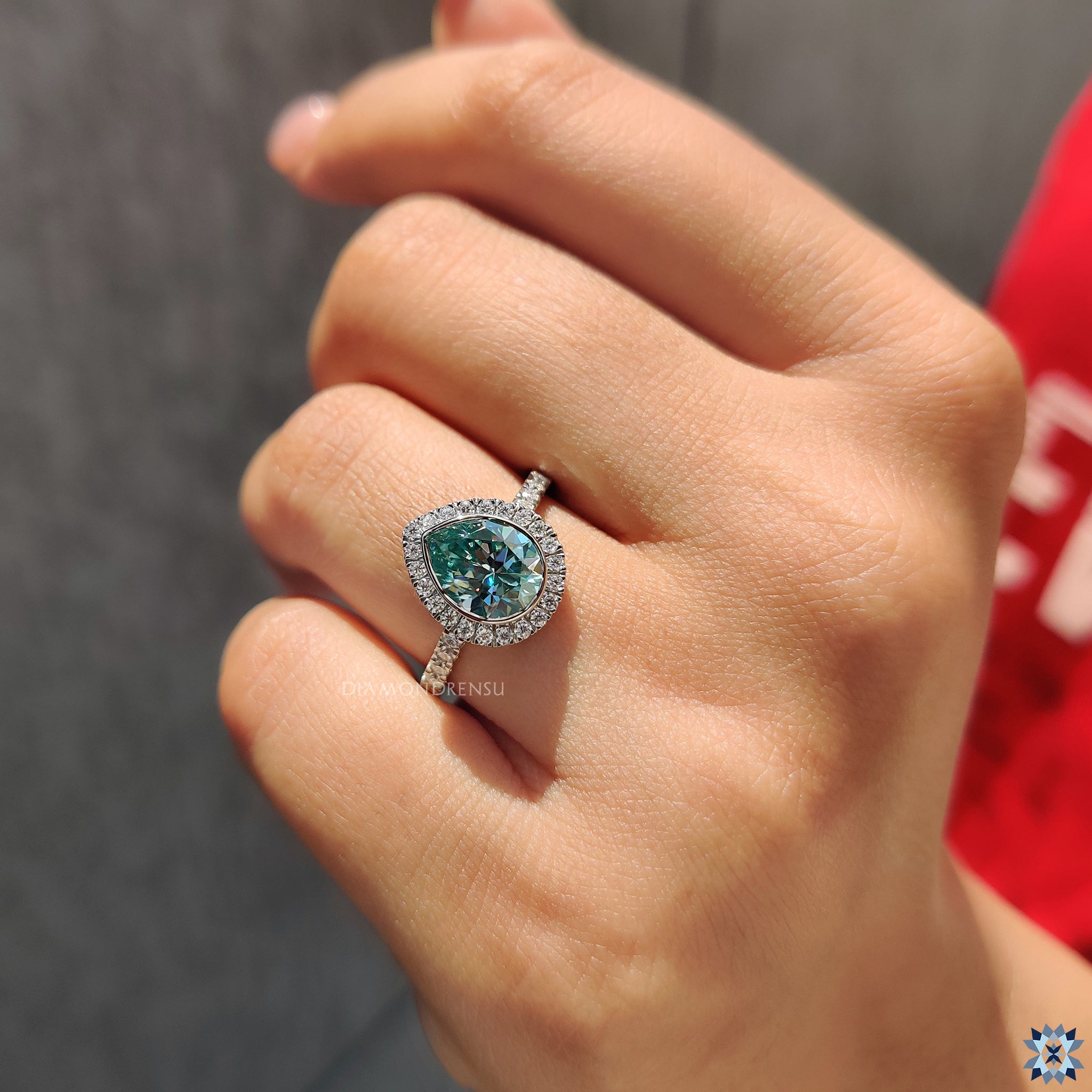 White gold engagement ring with pear moissanite and pave round band.
