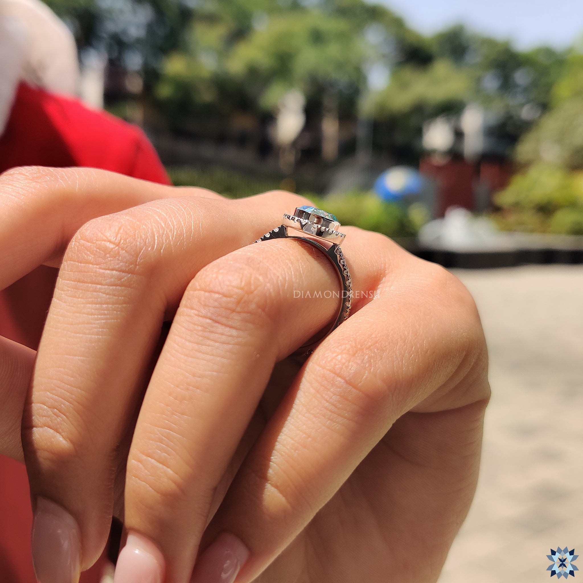Buy engagement ring with cyan blue moissanite and elegant halo detail.
