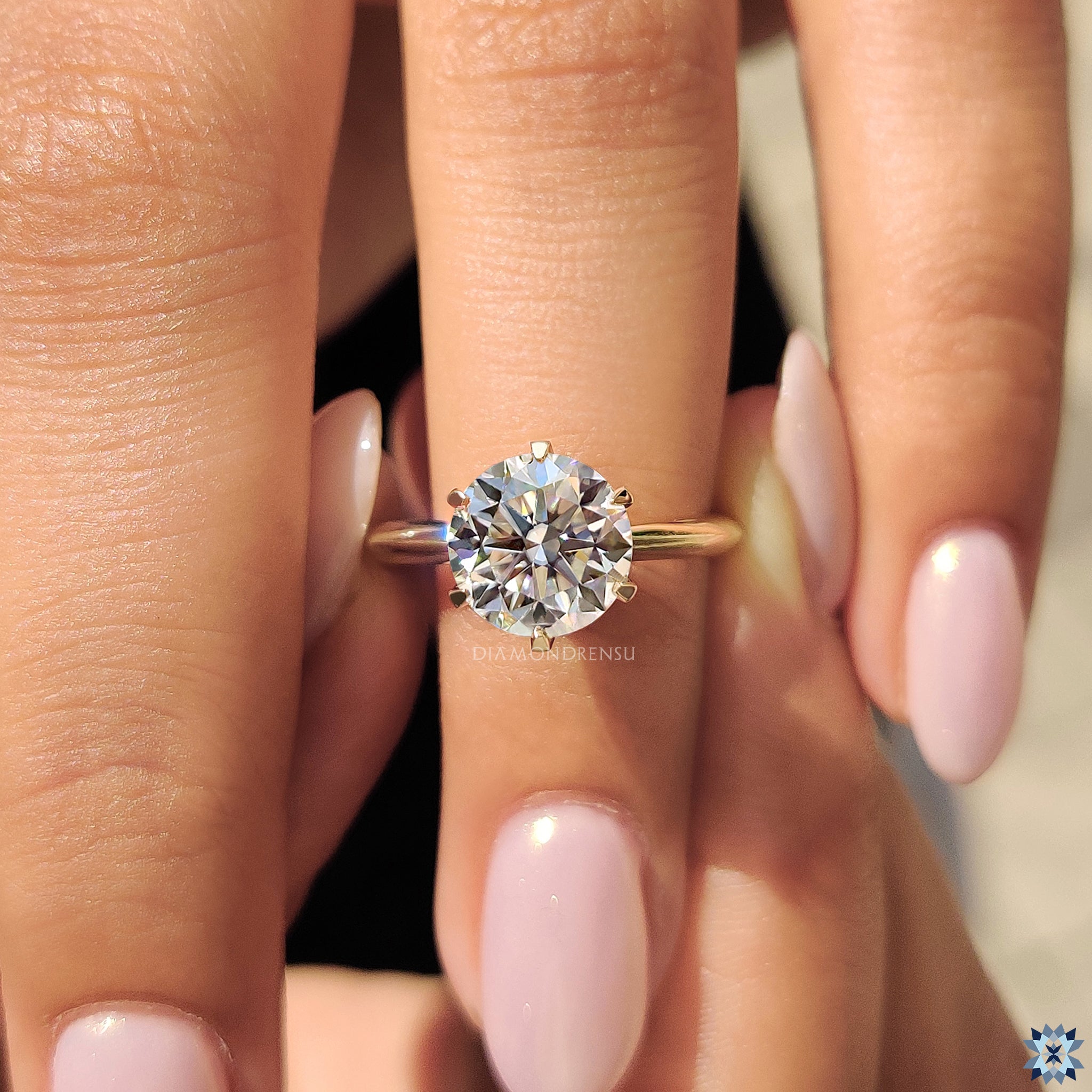 Yellow gold engagement ring with round moissanite in a minimalist solitaire setting.
