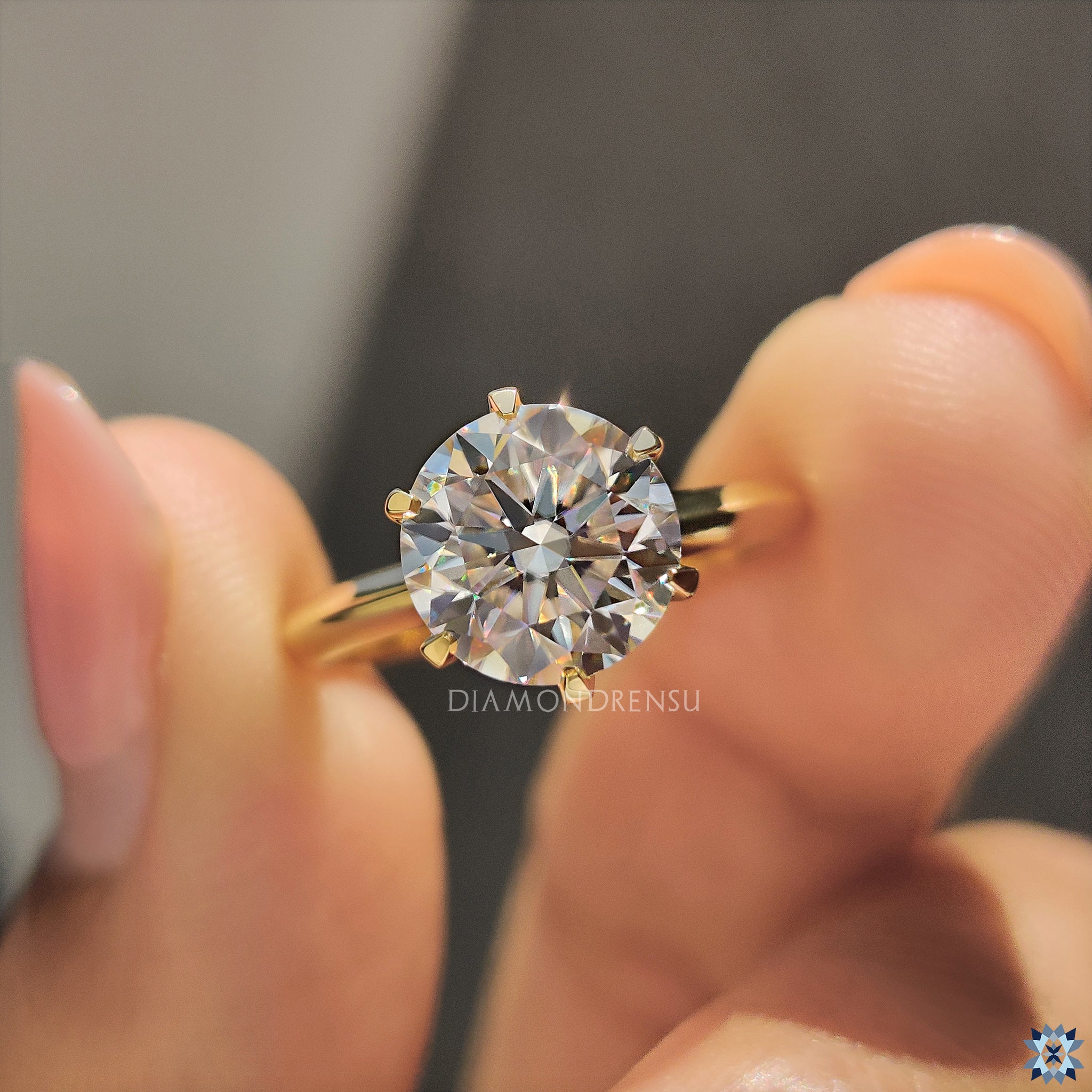 UK engagement ring with yellow gold band and solitaire moissanite centerpiece.
