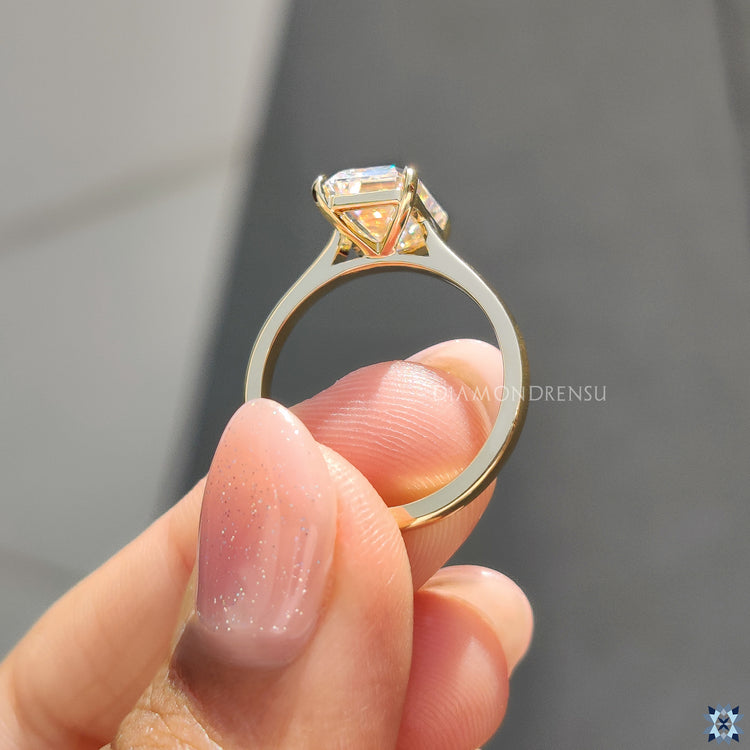 Buy engagement ring with emerald moissanite and sleek yellow gold finish.
