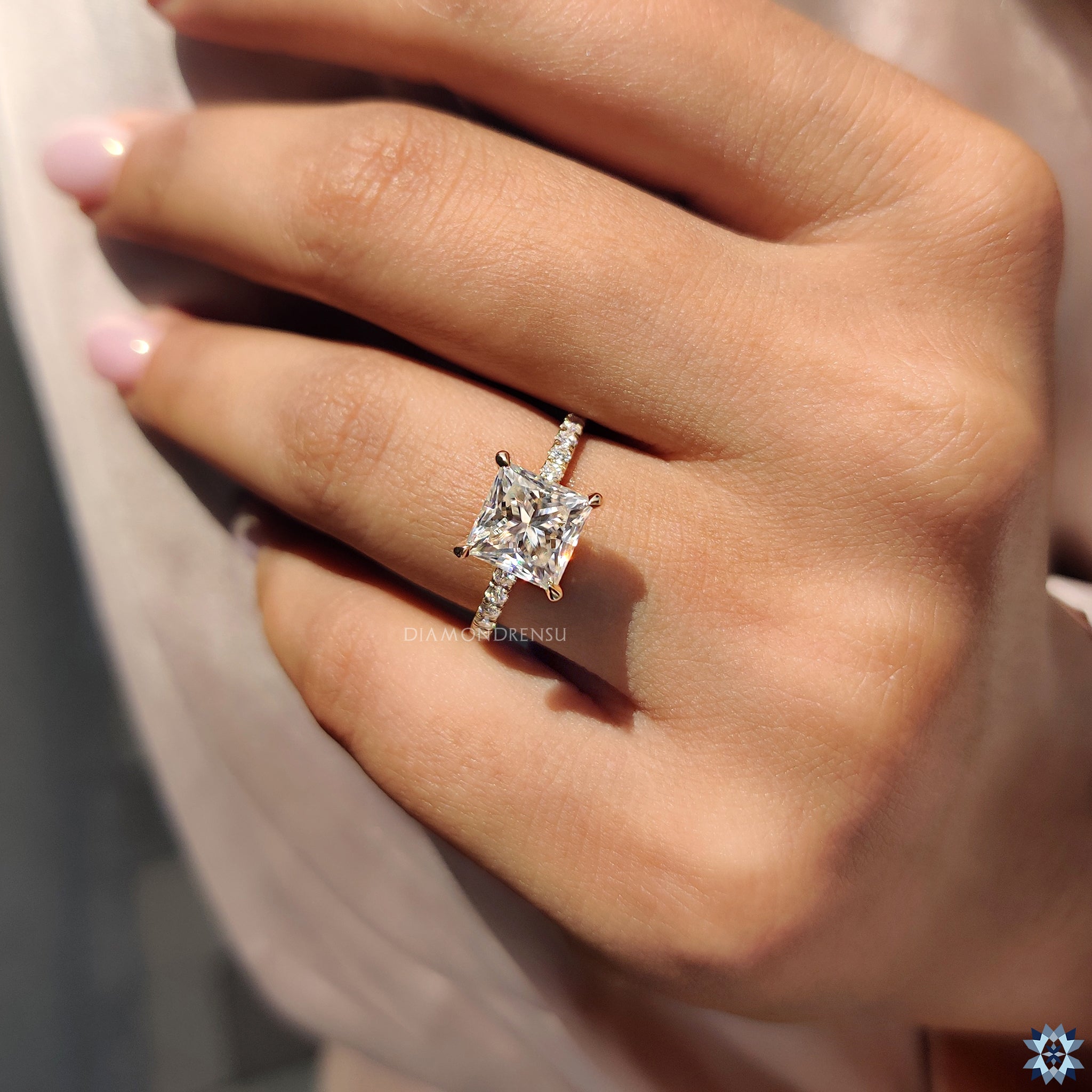 Elegant princess cut Moissanite ring with pave band and yellow gold shank.
