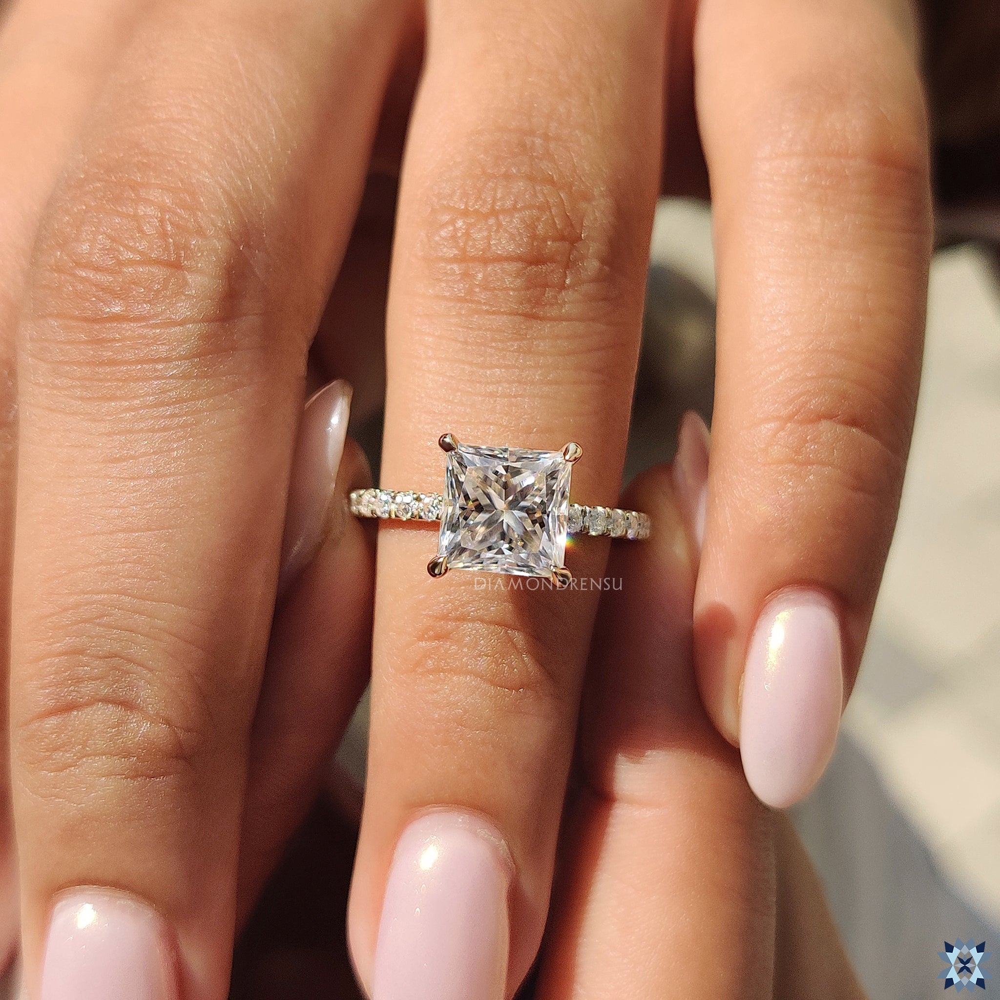 Moissanite gold engagement ring with secure 4 claw prong and brilliant pave band.
