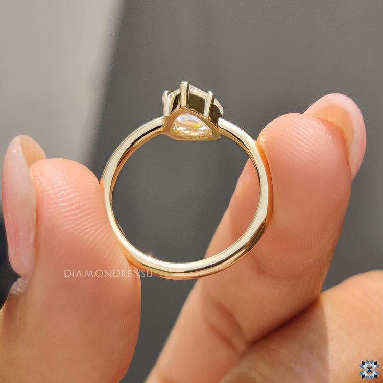 Yellow gold solitaire setting with pear-shaped rose cut Moissanite stone.
