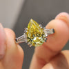 Canary yellow pear cut Moissanite ring with tapered baguette side stones in white gold setting.
