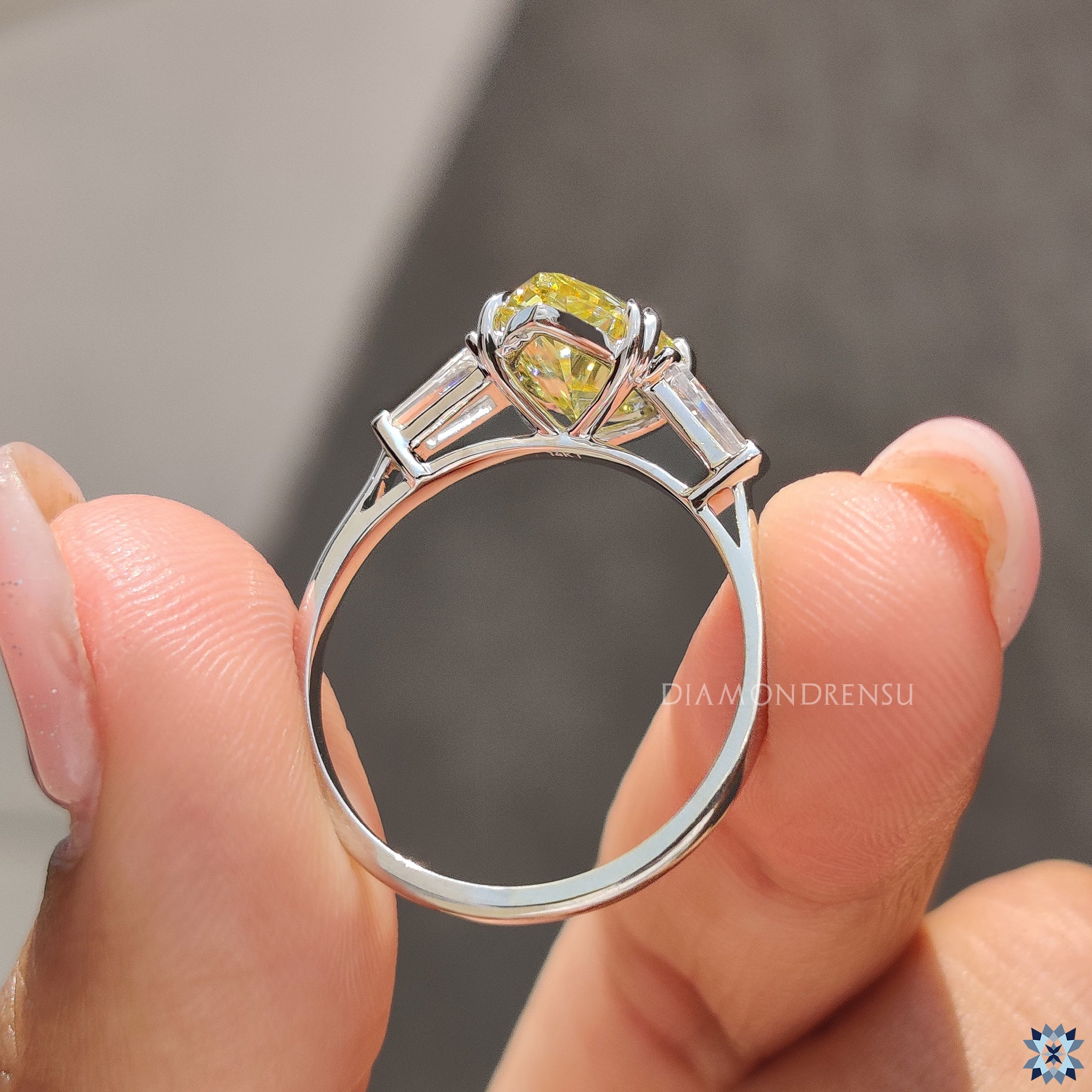 Buy engagement ring with yellow pear Moissanite and white gold three-stone design.

