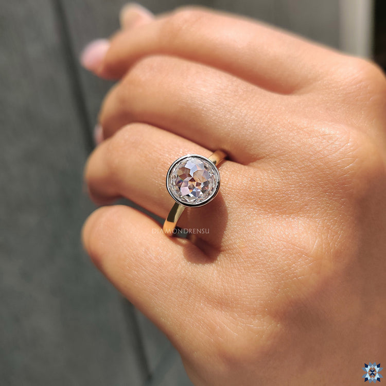 Moissanite for an engagement ring featuring bezel setting and round rose cut stone.
