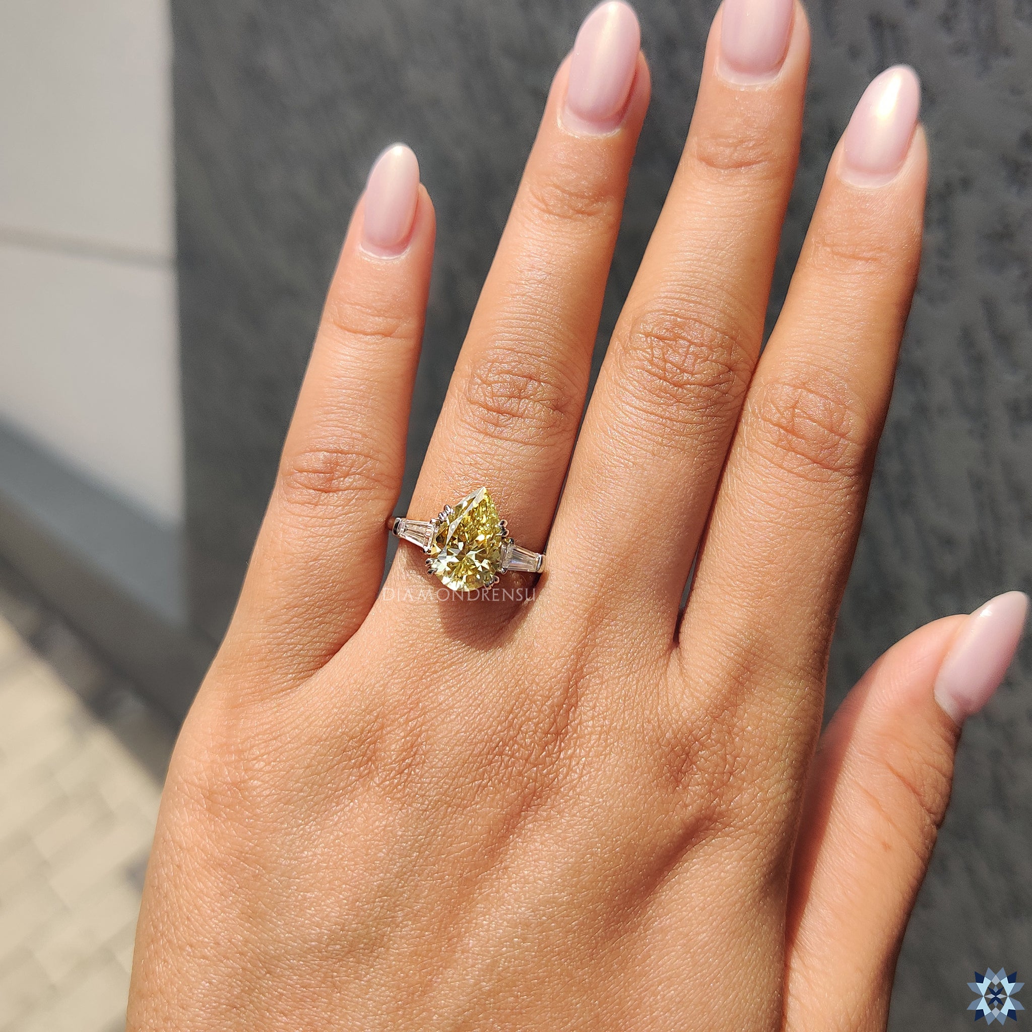 White gold engagement ring featuring vibrant canary yellow pear Moissanite and baguette sides.
