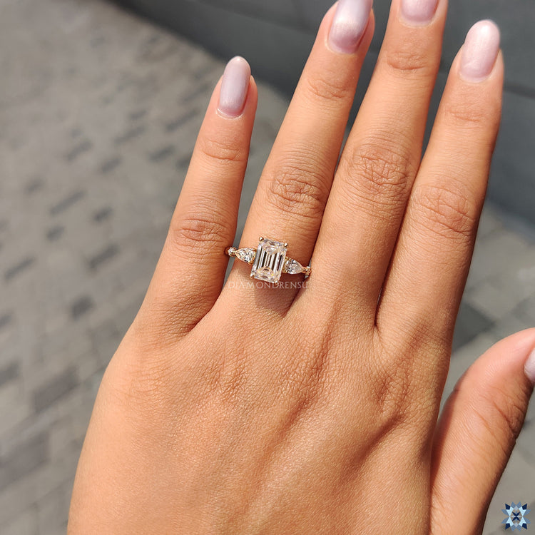 Handmade yellow gold engagement ring with emerald and pear moissanite stones.
