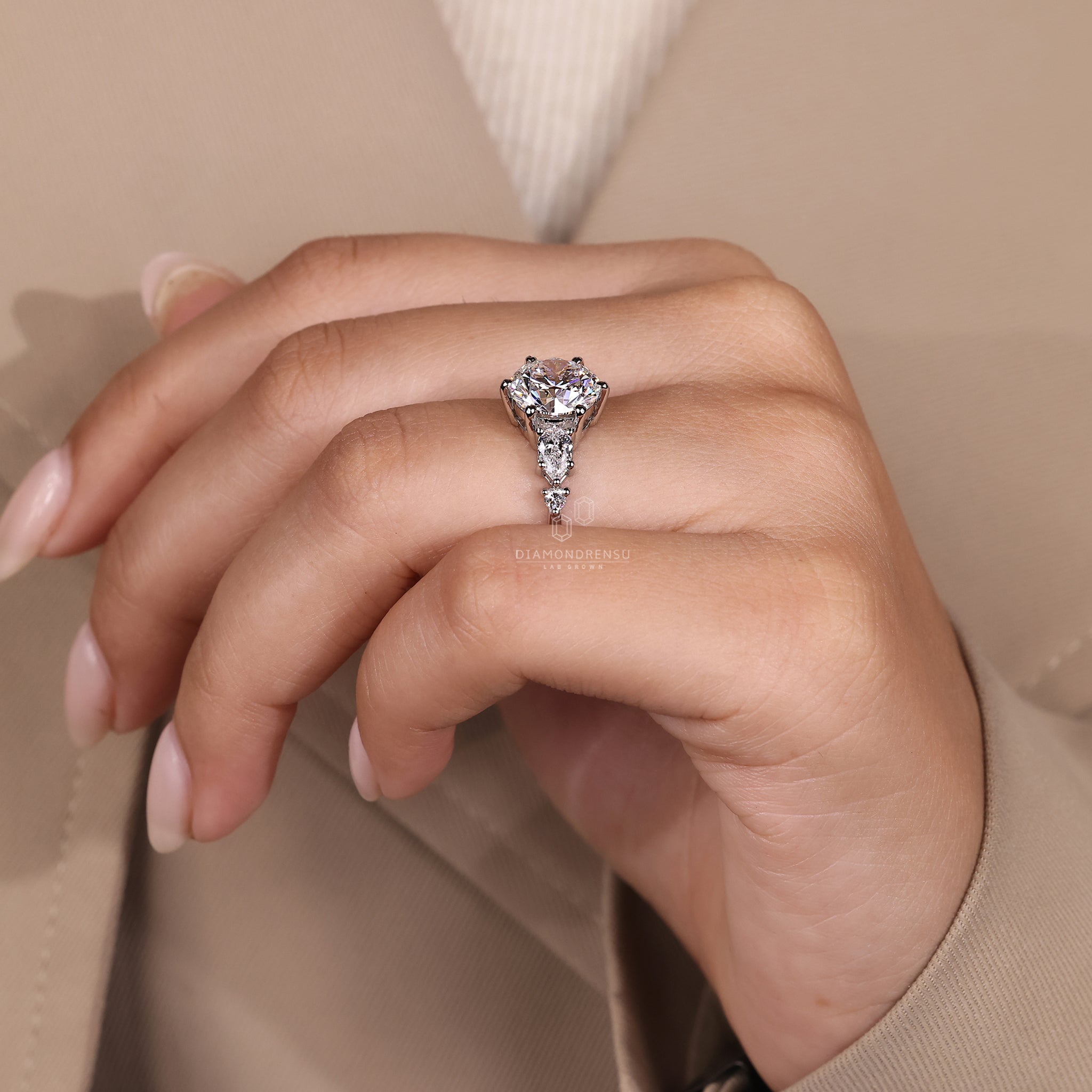 Prong setting ring with round center and pear sides.
