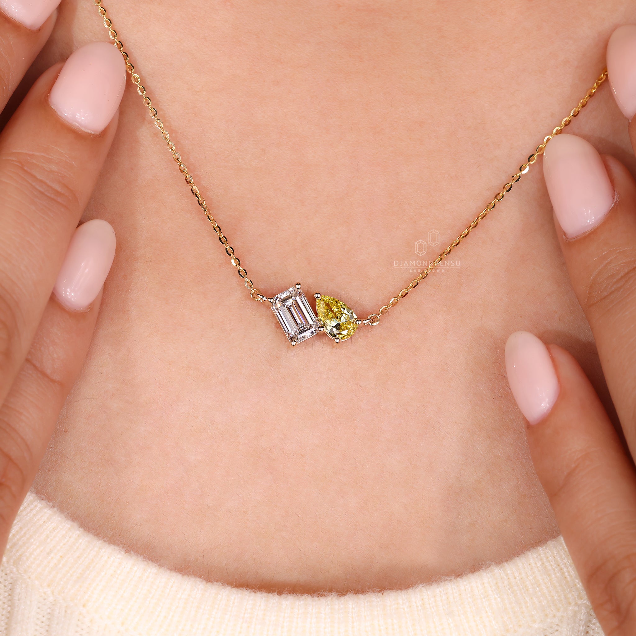 Yellow pear diamond and emerald cut pendant set in warm yellow gold.
