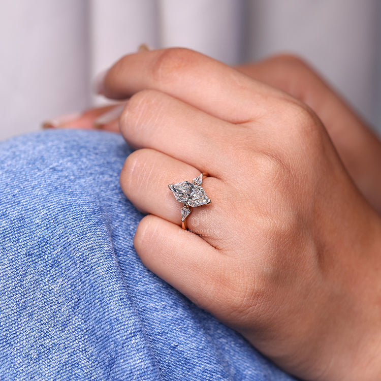 Kite cut side stone in a 3 stone yellow gold ring.
