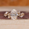 Gold oval diamond engagement ring with marquise and round stones