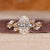 Gold oval diamond engagement ring with marquise and round stones