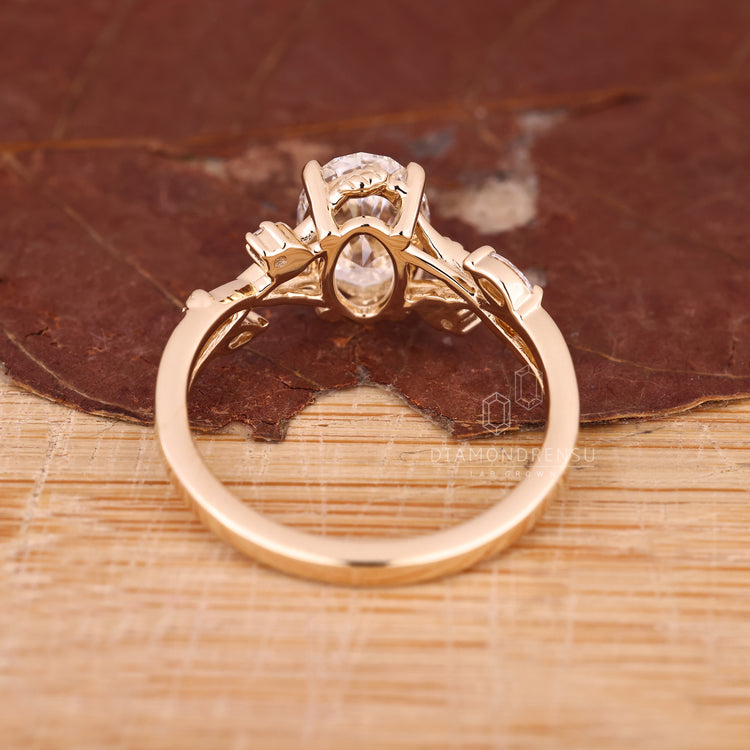 Gold engagement ring with oval diamond and nature-inspired design