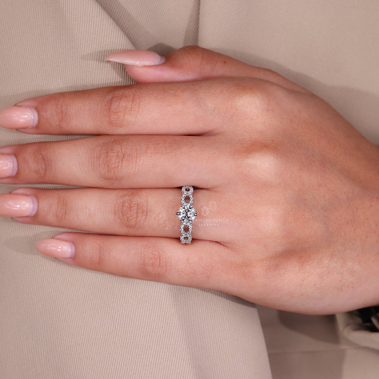 Round diamond ring with twisted pave band, set in white gold.
