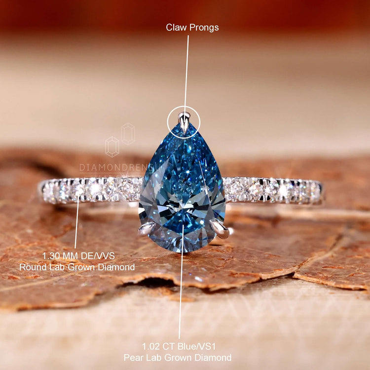 3 prong claw setting in a blue diamond pear shaped ring, ideal for women in the UK.
