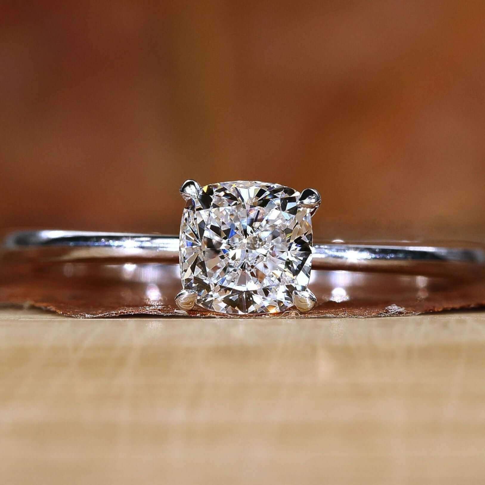 Cushion cut diamond ring with brilliant sparkle in a claw prong setting.