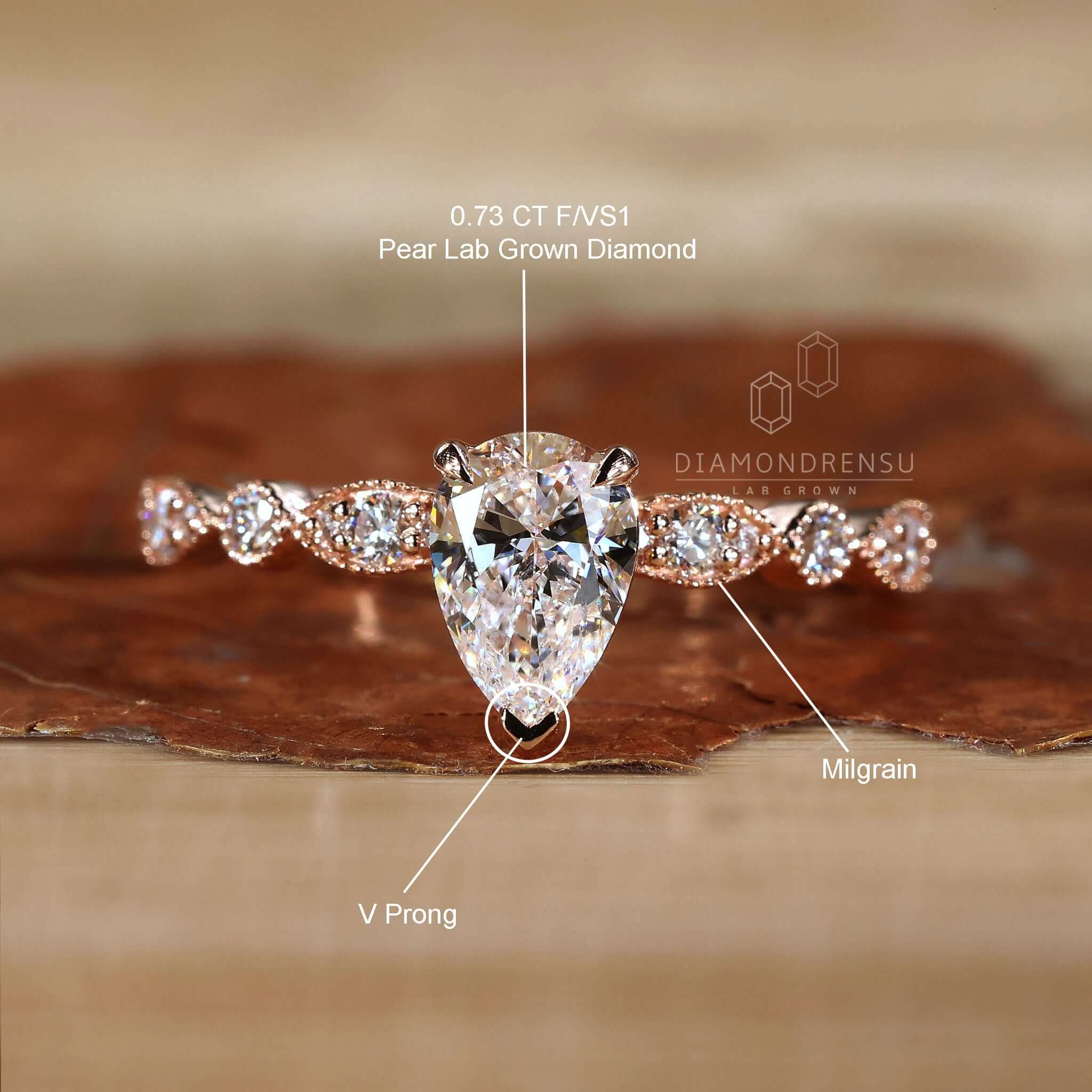 Round diamond ring designed with pear shaped engagement ring features and milgrain detailing.
