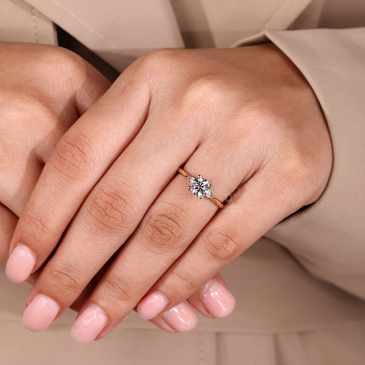 Round diamond ring with four prong and side stones.