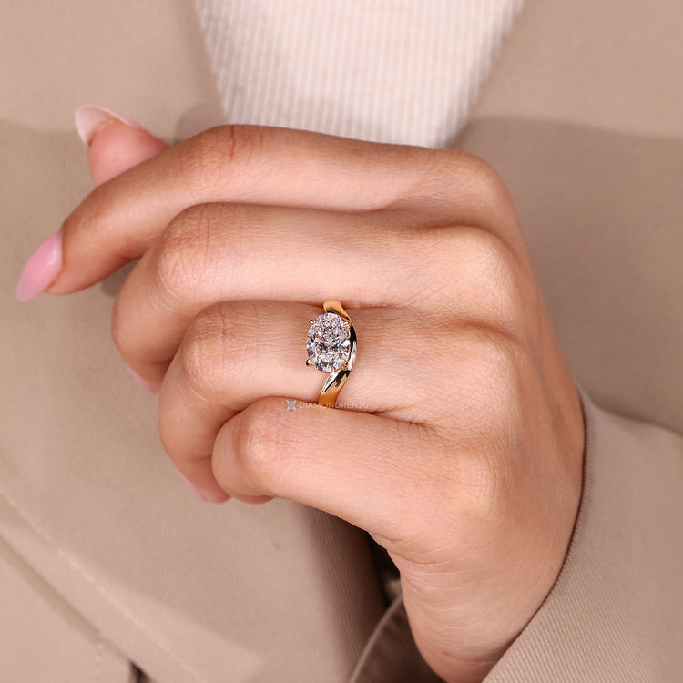 Oval diamond ring with four claw prong setting.