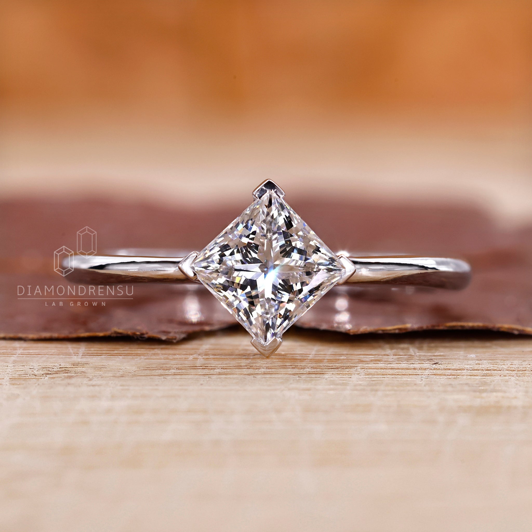 White gold ring with prong setting and princess cut diamond.