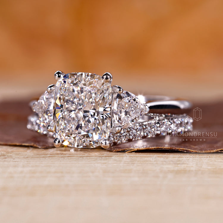 White gold bridal set with cushion cut centre and round diamond band.
