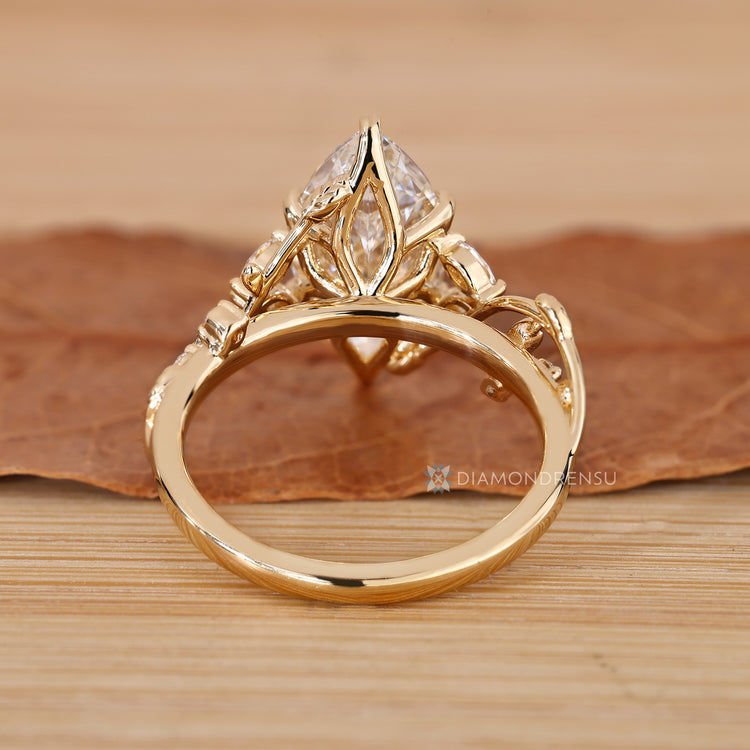 Marquise ring with round side stones and prong setting.
