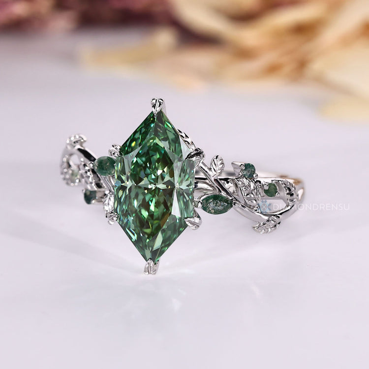 Marquise and round side stone ring with green centre.