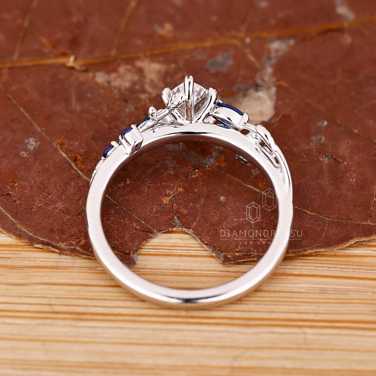 Nature style ring with marquise diamond and leaf prongs.