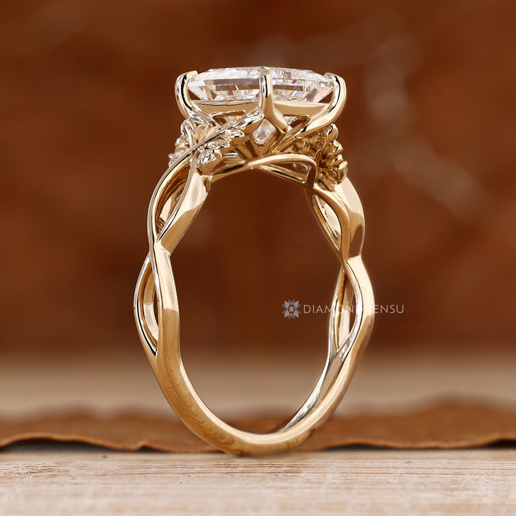 Princess diamond ring with sculpted leaf motifs and prongs.