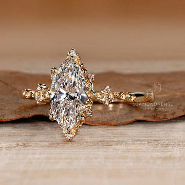 Diamondrensu marquise diamond ring with round side accents design.