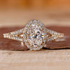 Oval cut engagement ring with round halo and split shank.