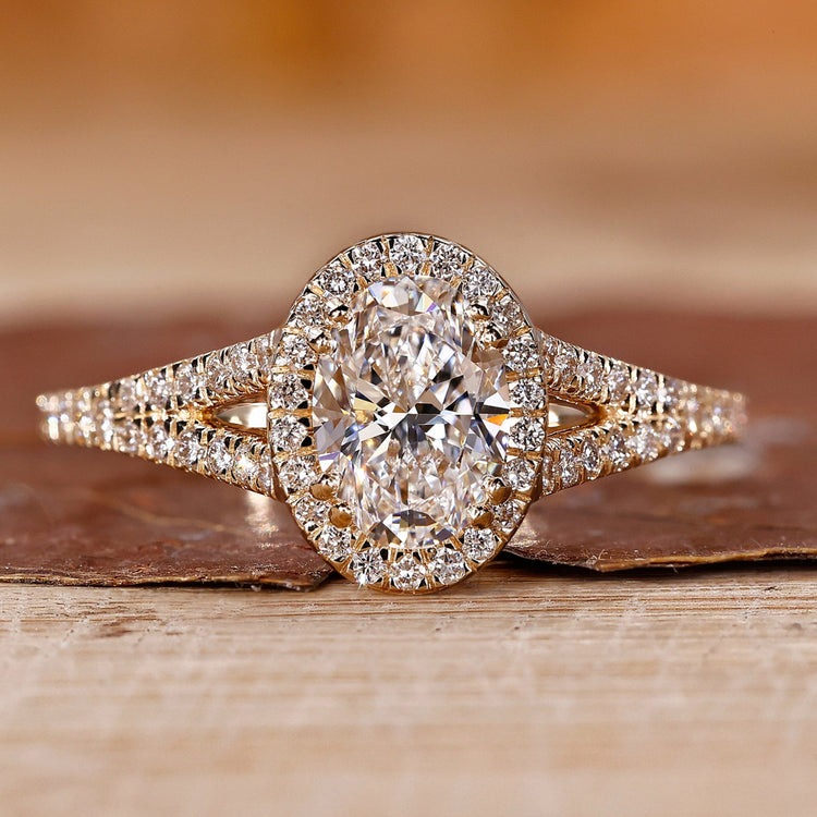 Oval cut engagement ring with round halo and split shank.