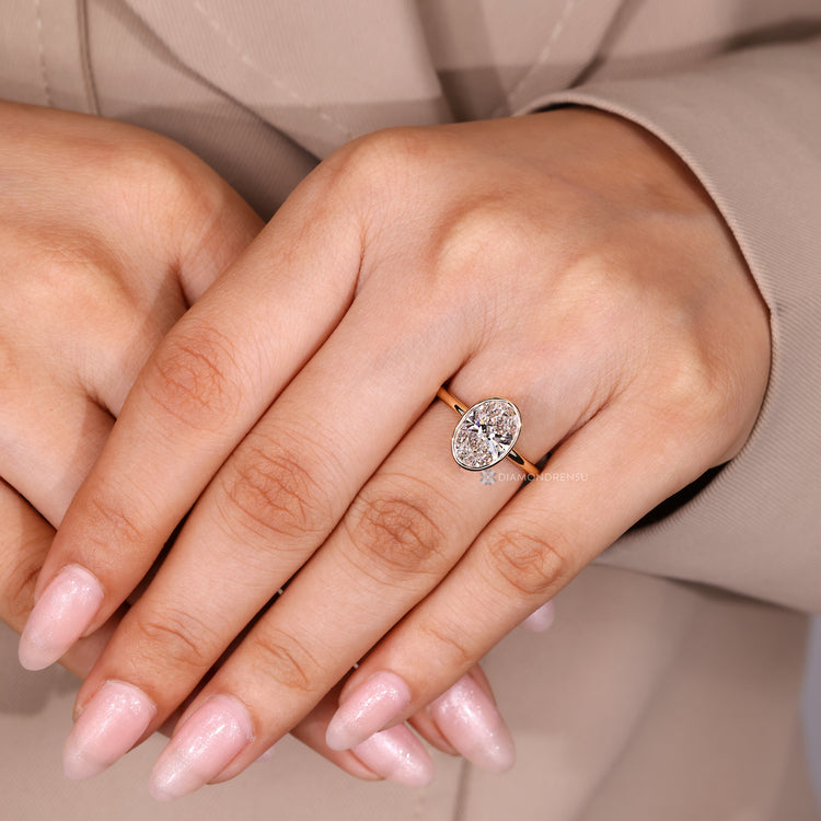 Oval cut lab grown diamond ring with bezel setting.