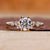 Side stone engagement ring crafted with round diamond center.