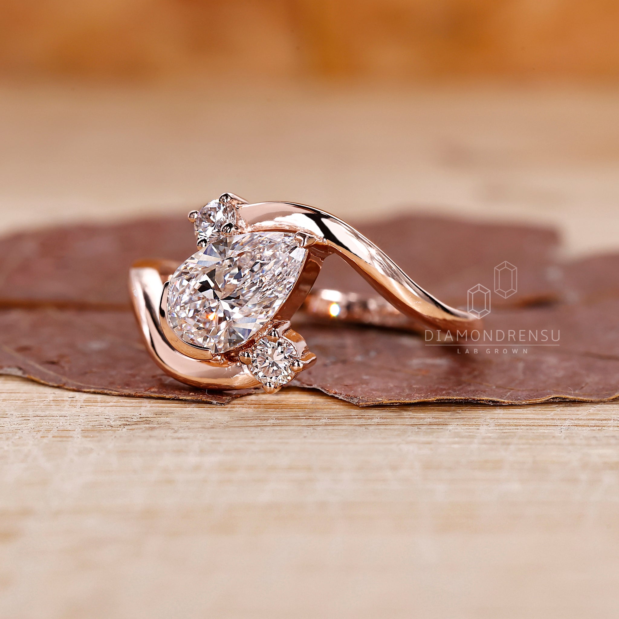 Rose gold ring with bypass and pear cut design.
