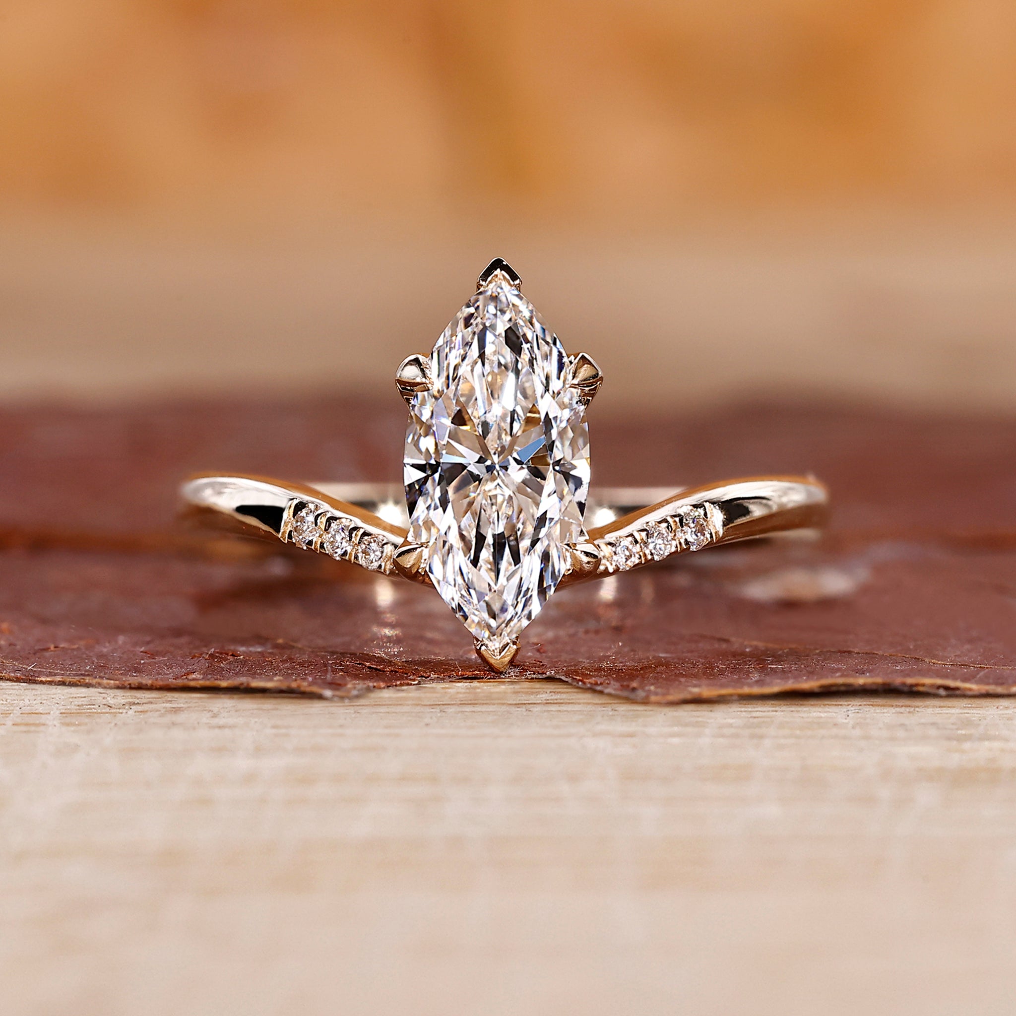 Yellow gold marquise diamond engagement ring with tapered shank band.
