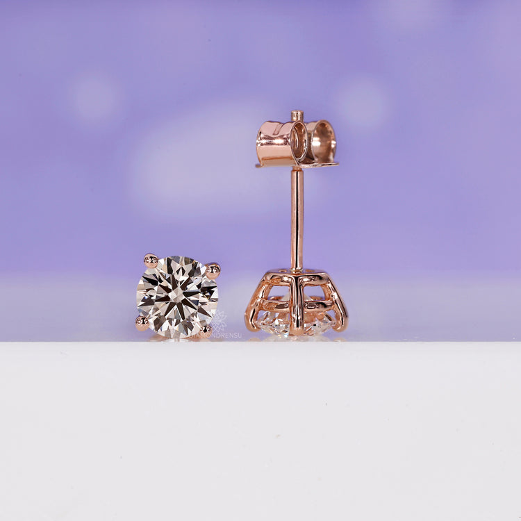 Handmade rose gold diamond stud earrings with secure prong settings.