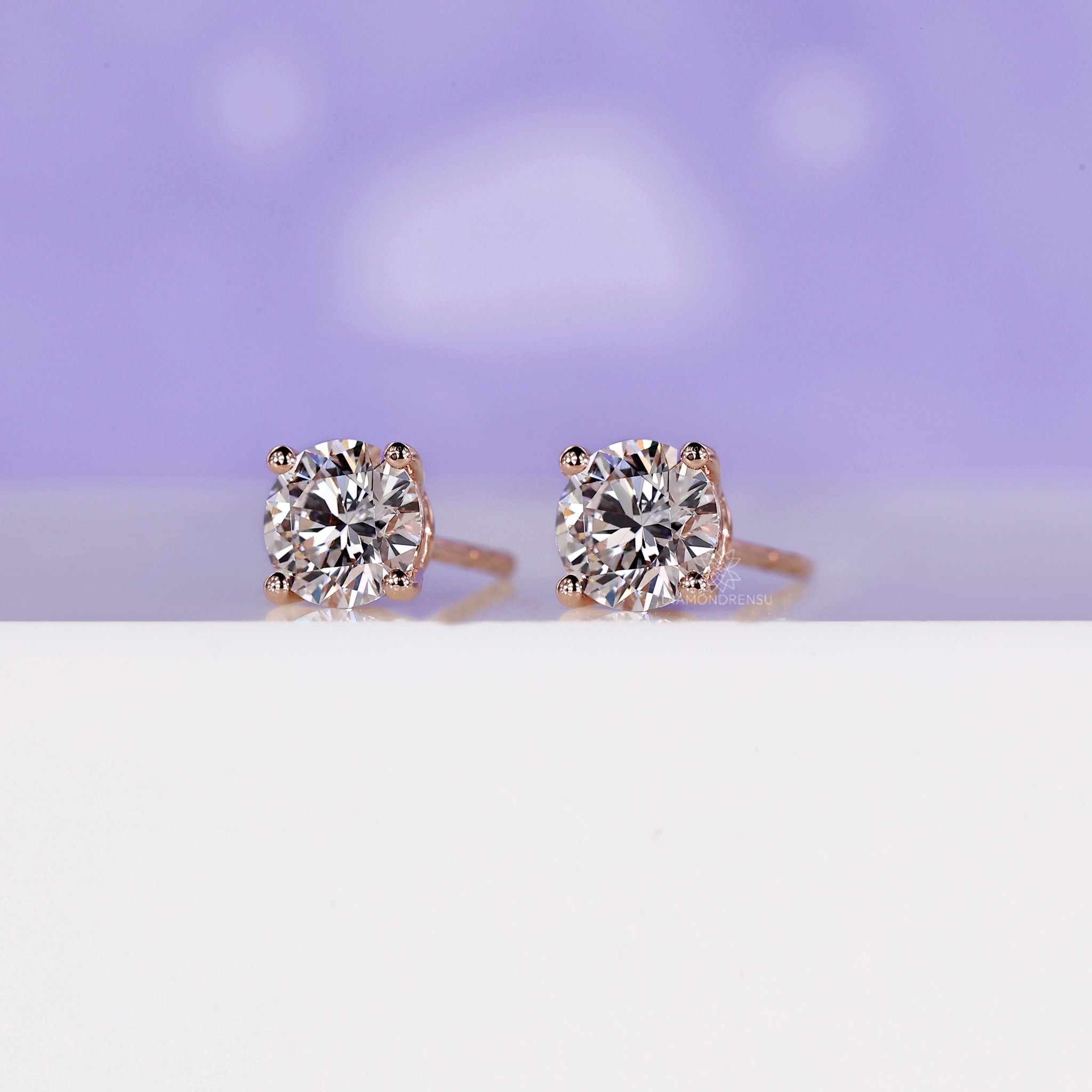 Lab grown diamond earrings set in rose gold prong settings.